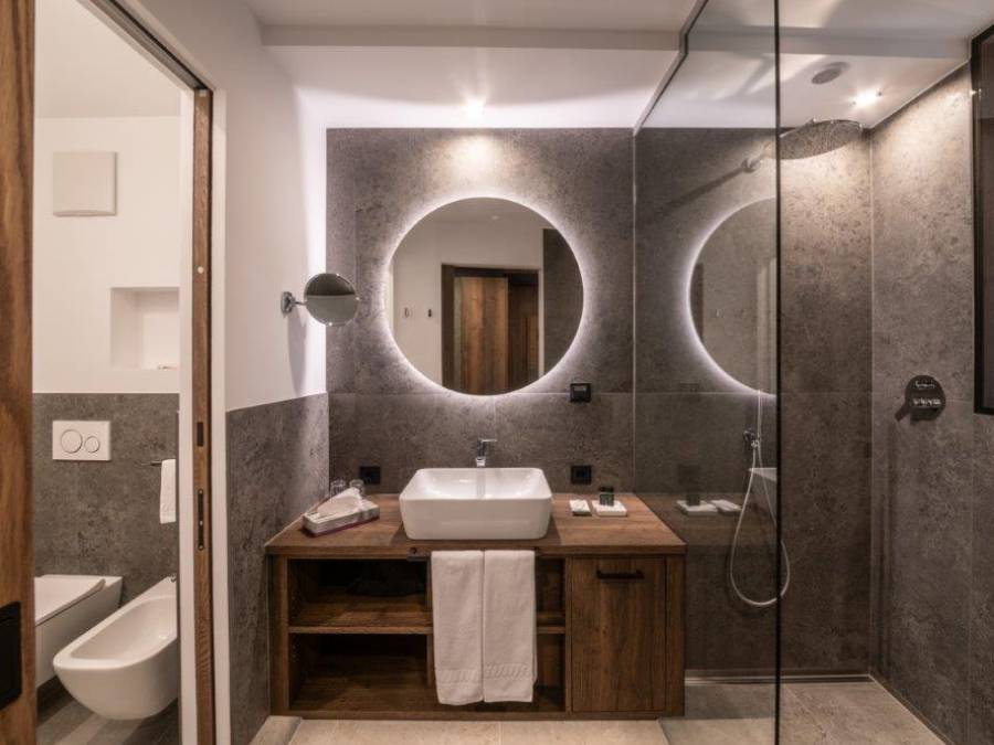 Modernes Bad mit Regendusche, Waschbecken und beleuchtetem Rundspiegel - Kiebacher Wahlen