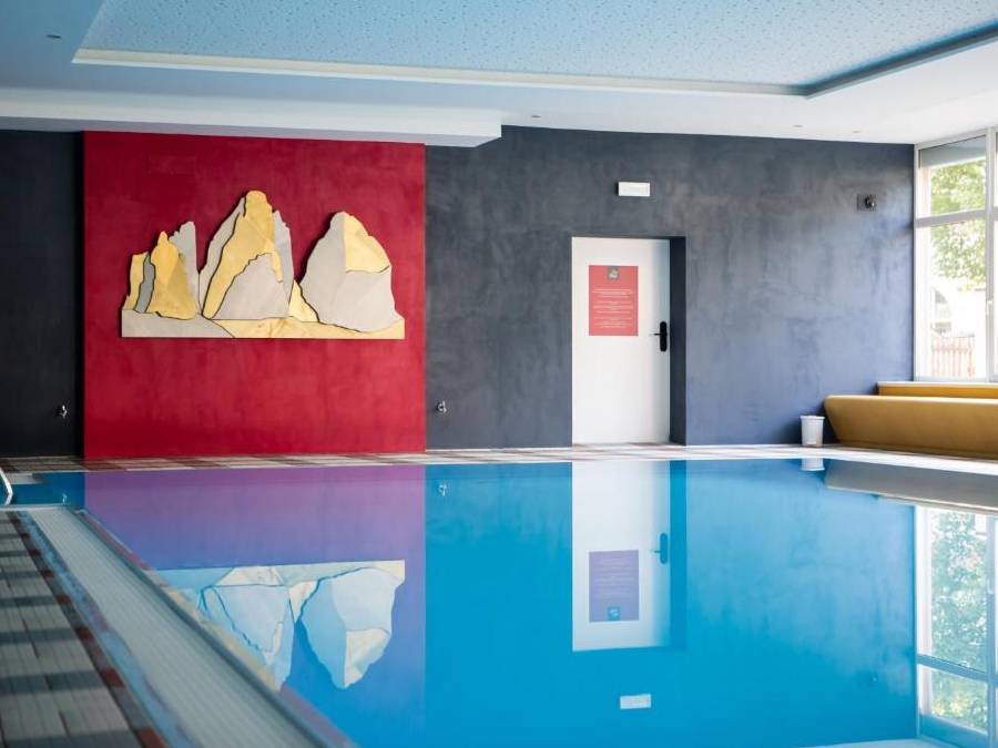 Waschbecken mit dunkler Wand und großem Bild der Drei Zinnen im Hintergrund - Kiebacher Wahlen