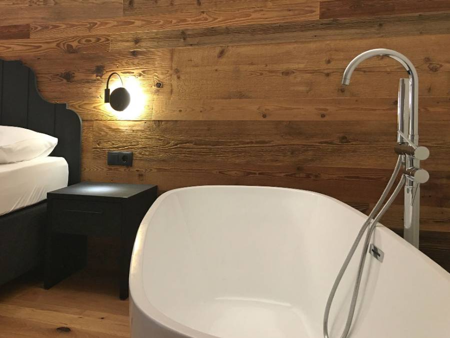 Hotelzimmer mit freistehender Badewanne neben dem Bett - Kiebacher Wahlen