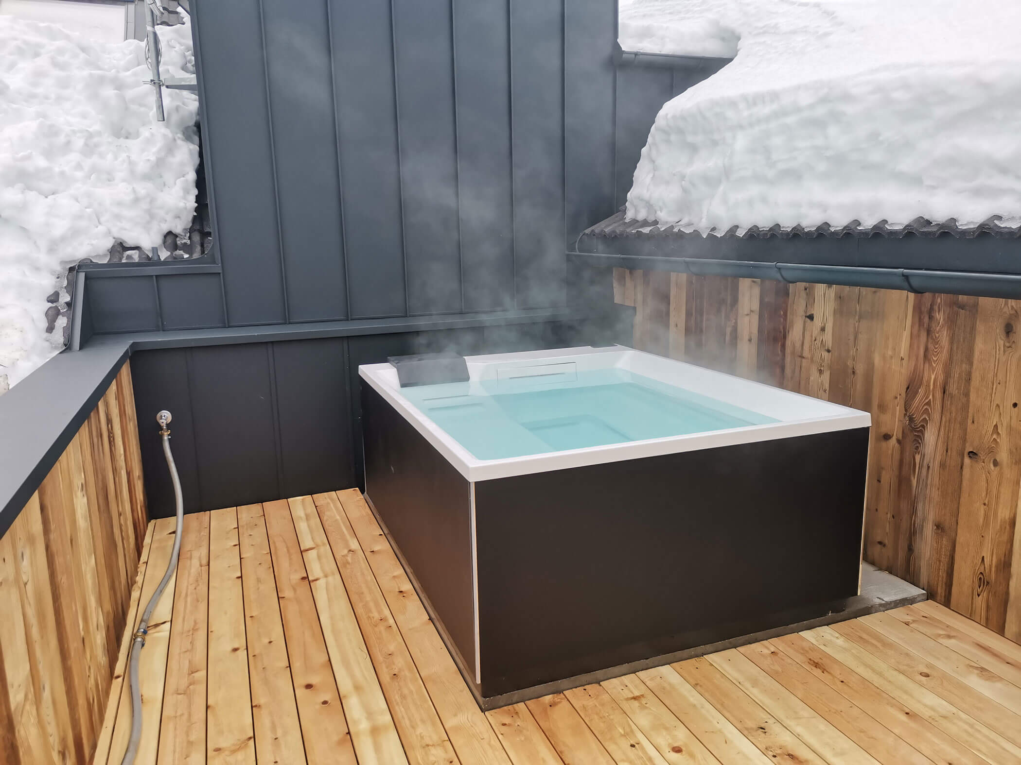 Idromassaggio scuro in inverno su un balcone di legno - Kiebacher Wahlen